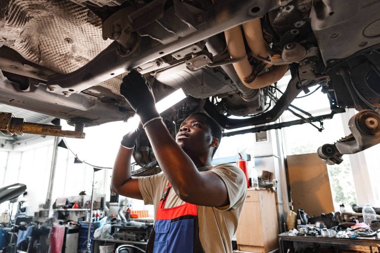 young-african-mechanic-in-uniform-working-under-th-2026-03-23-23-49-48-utc-1